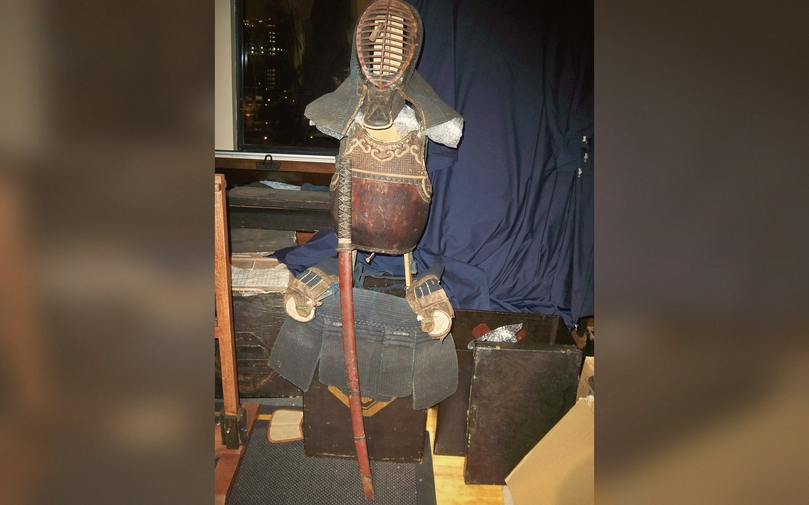 Kendo armor including mask, breastplate and gloves displayed on a stand indoors